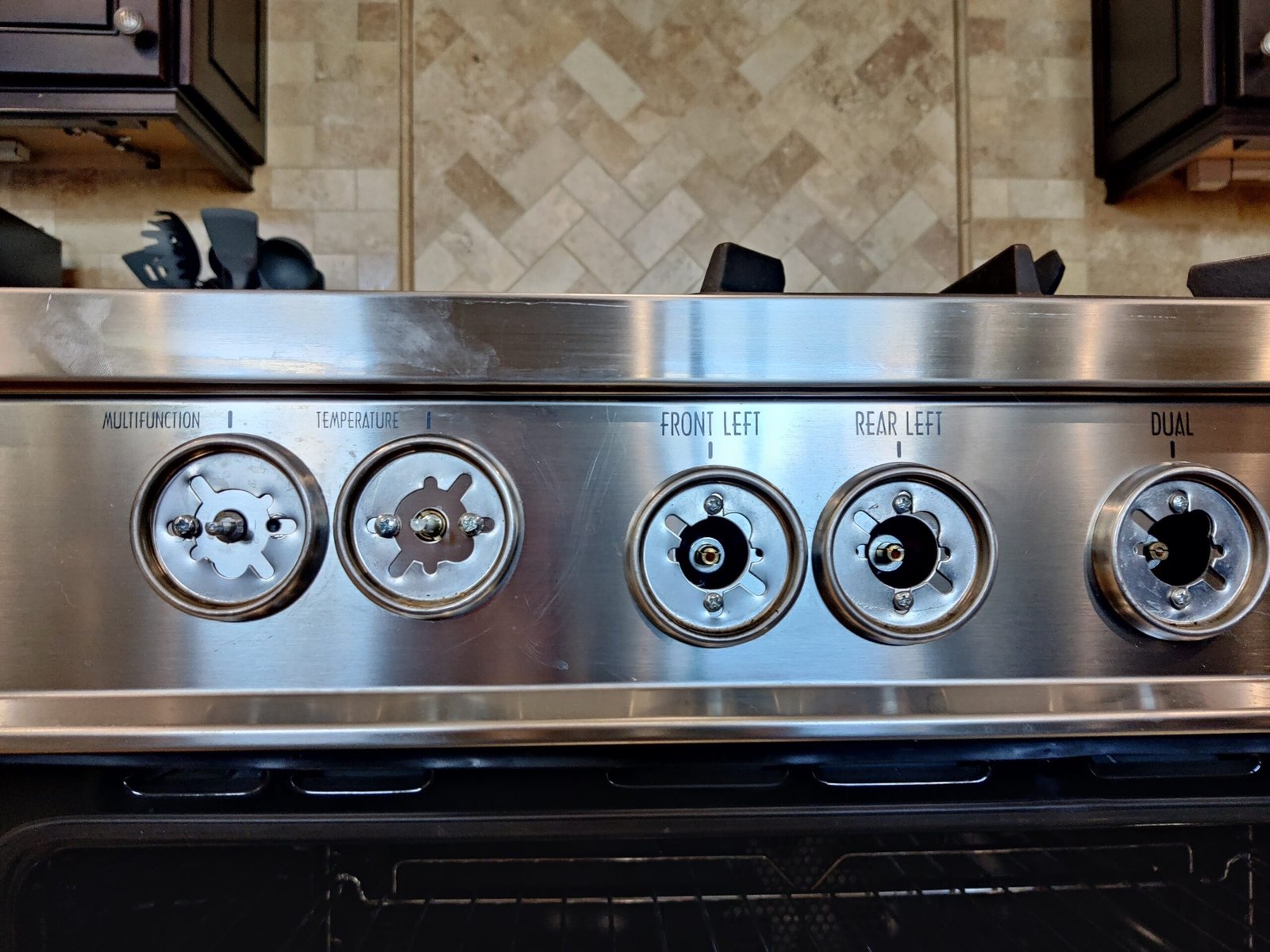 Close-up of a Wolf gas range control panel disassembled for professional gas valve and thermostat repair.